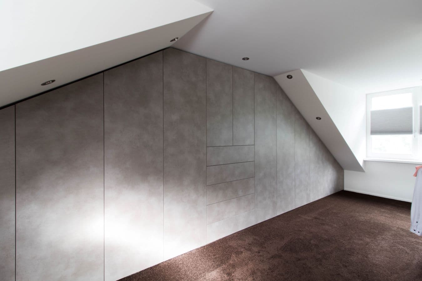 Betonlook kledingkast onder schuine kap