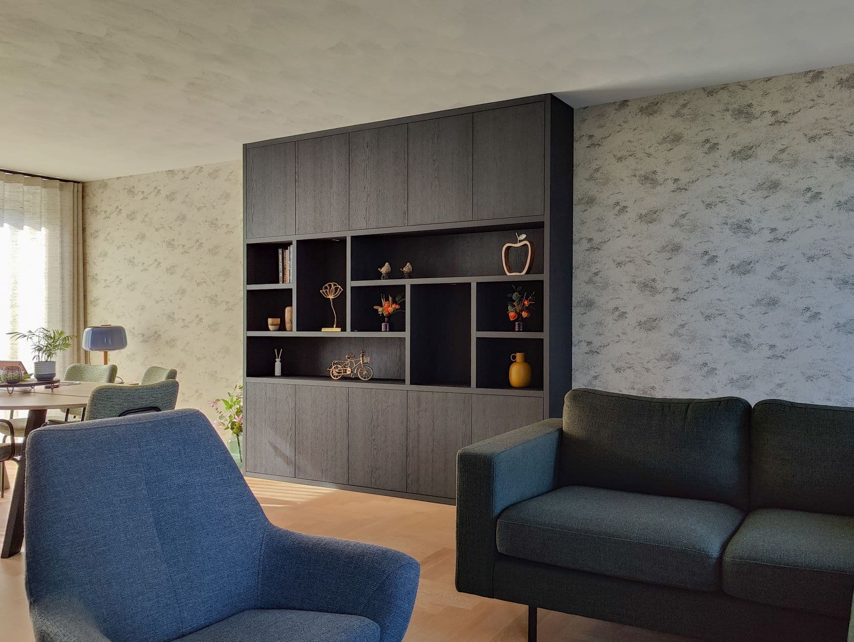 Op maat gemaakte donkere houtlook kastenwand in een gezellige woonkamer in Harderwijk.