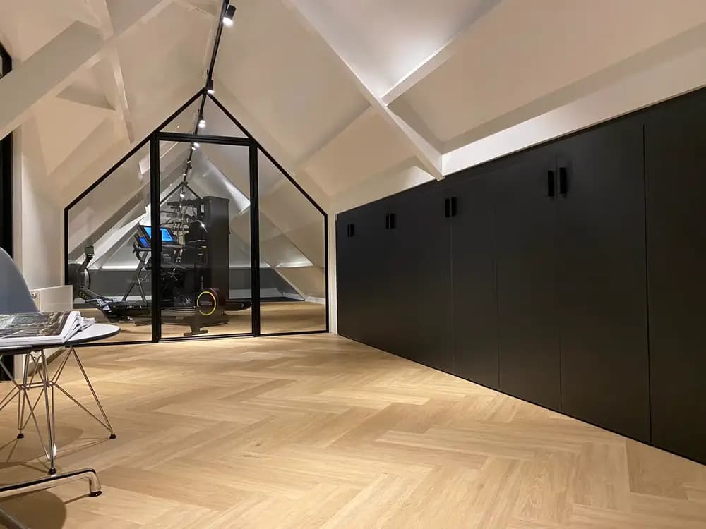 Zwarte minimalistische zolderkast met opbergruimte onder knieschot in moderne ruimte