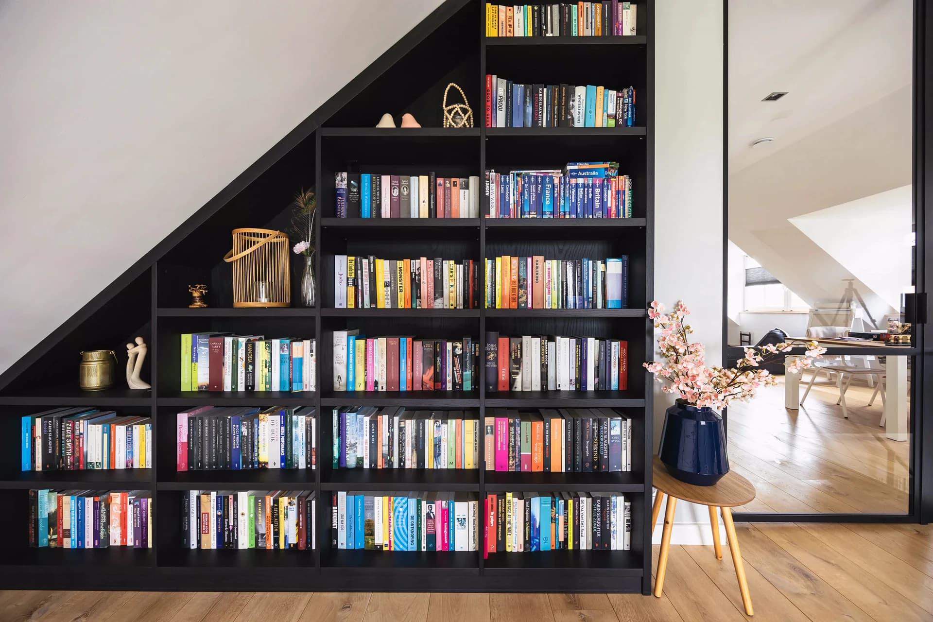 Schuine boekenkast op maat onder een schuin dak