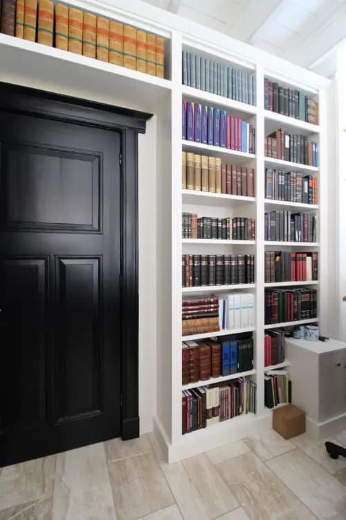Een maatwerk boekenkast die de deuropening stijlvol omsluit