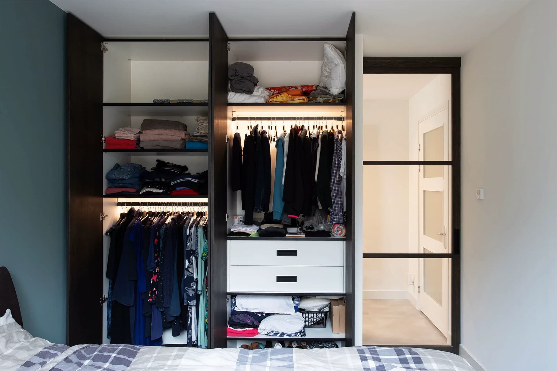 Geopende kledingkast met maatwerk interieur en verlichting