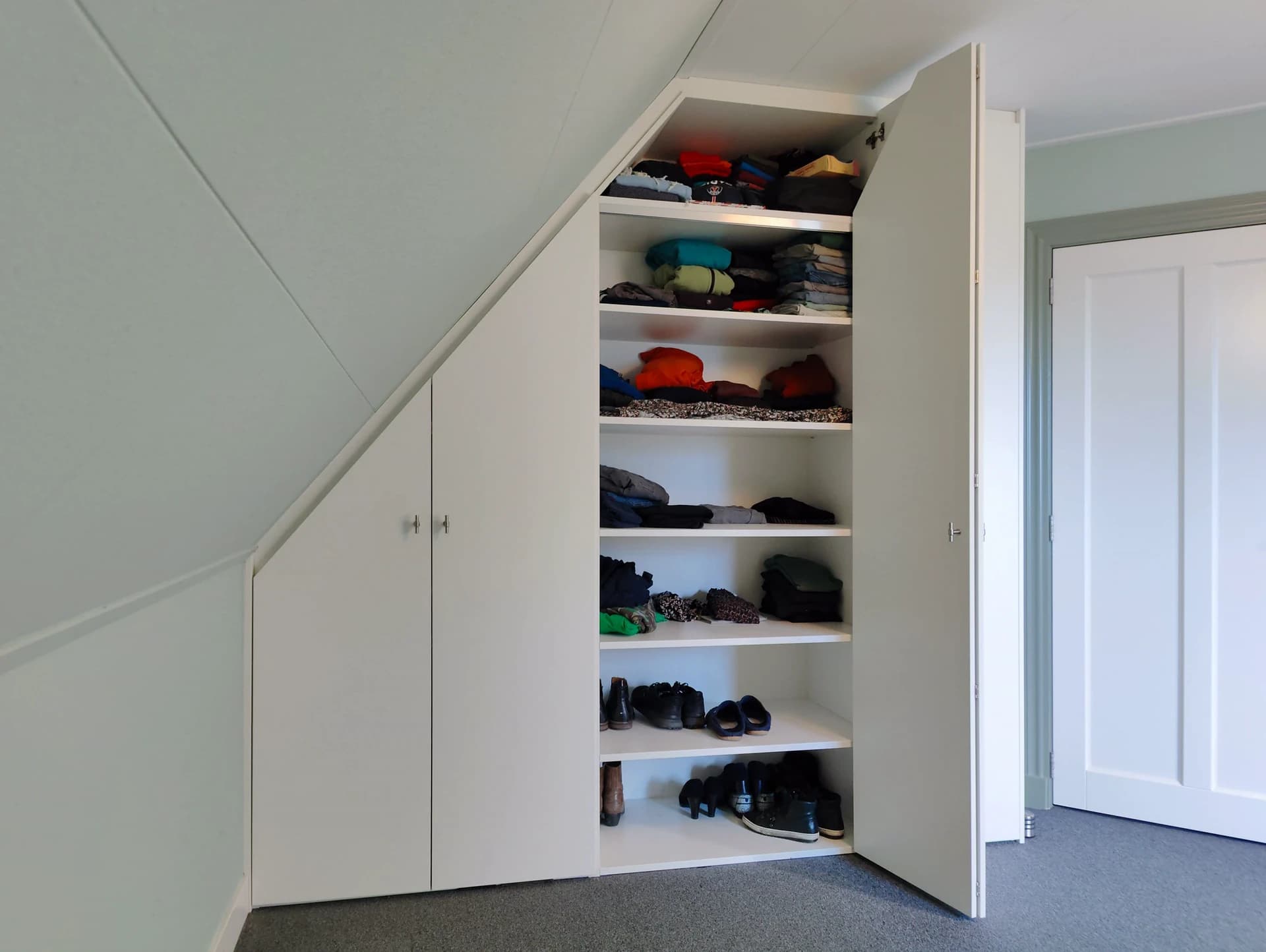 Inbouwkast onder schuin dak met optimaal gebruik van ruimte.