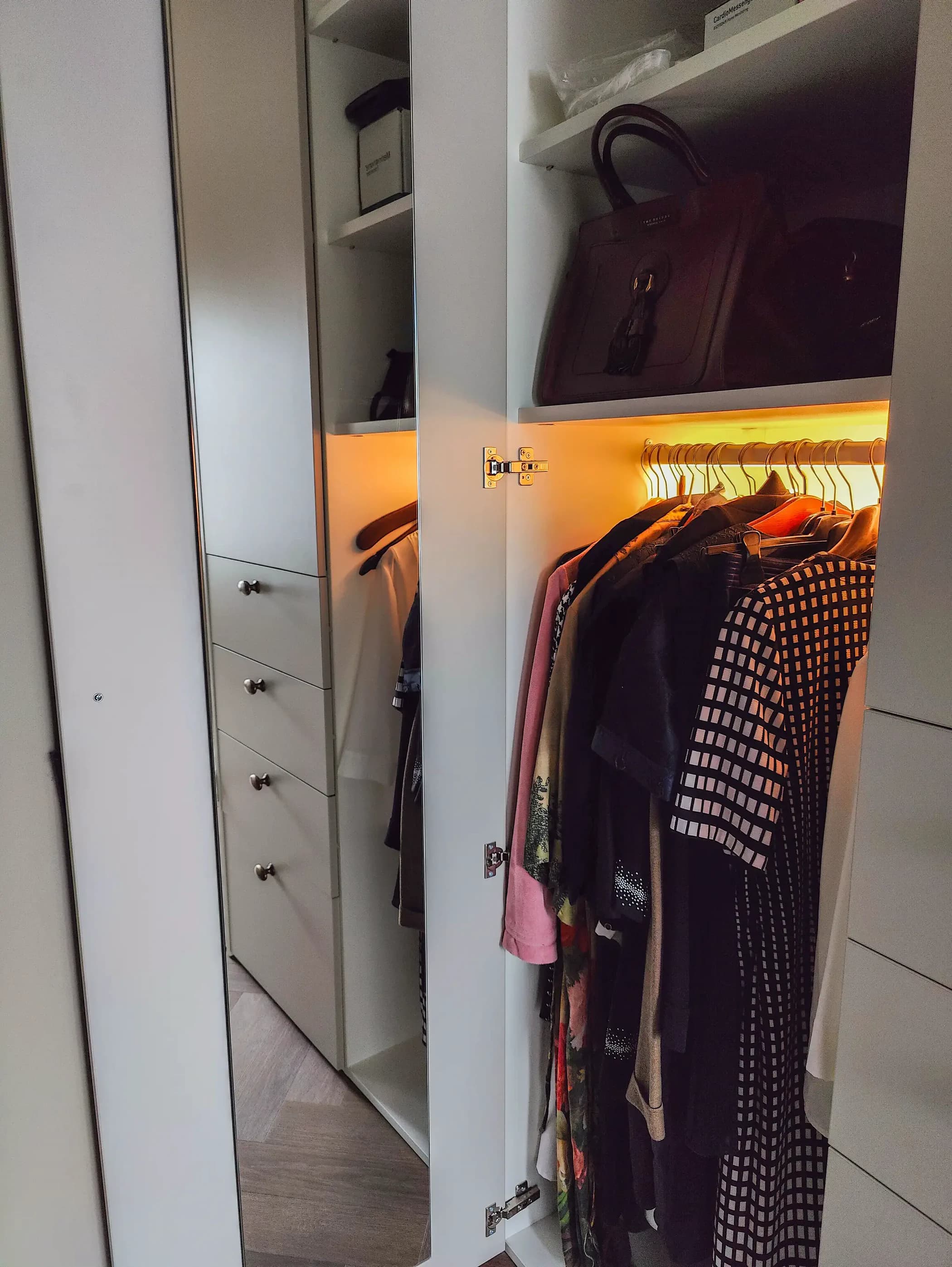 Kast met hangruimte en verlichting in een klassieke, chique inloopkast in Barneveld.