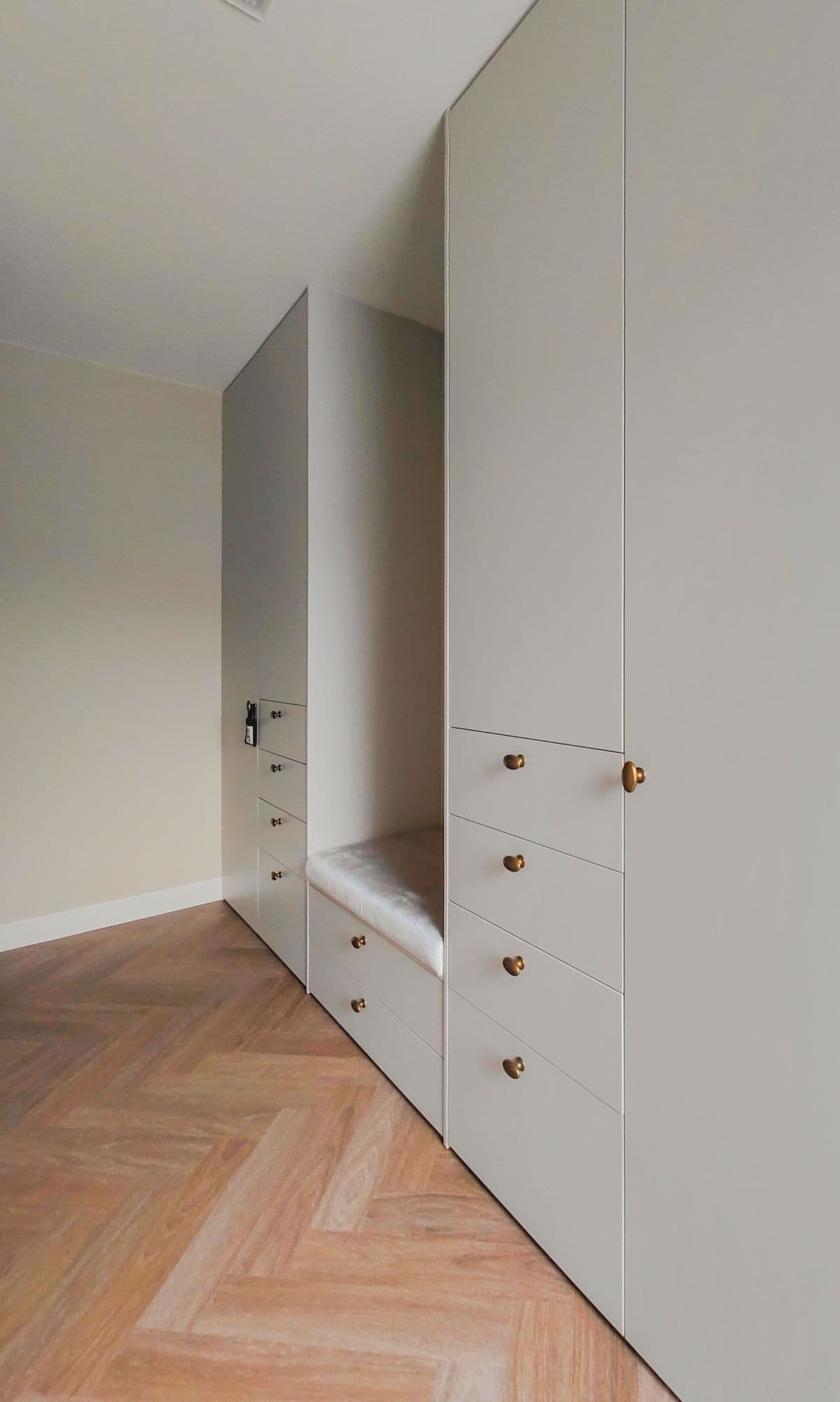 Zijaanzicht van een klassieke, chique inloopkast met ingebouwd zitje in Barneveld.