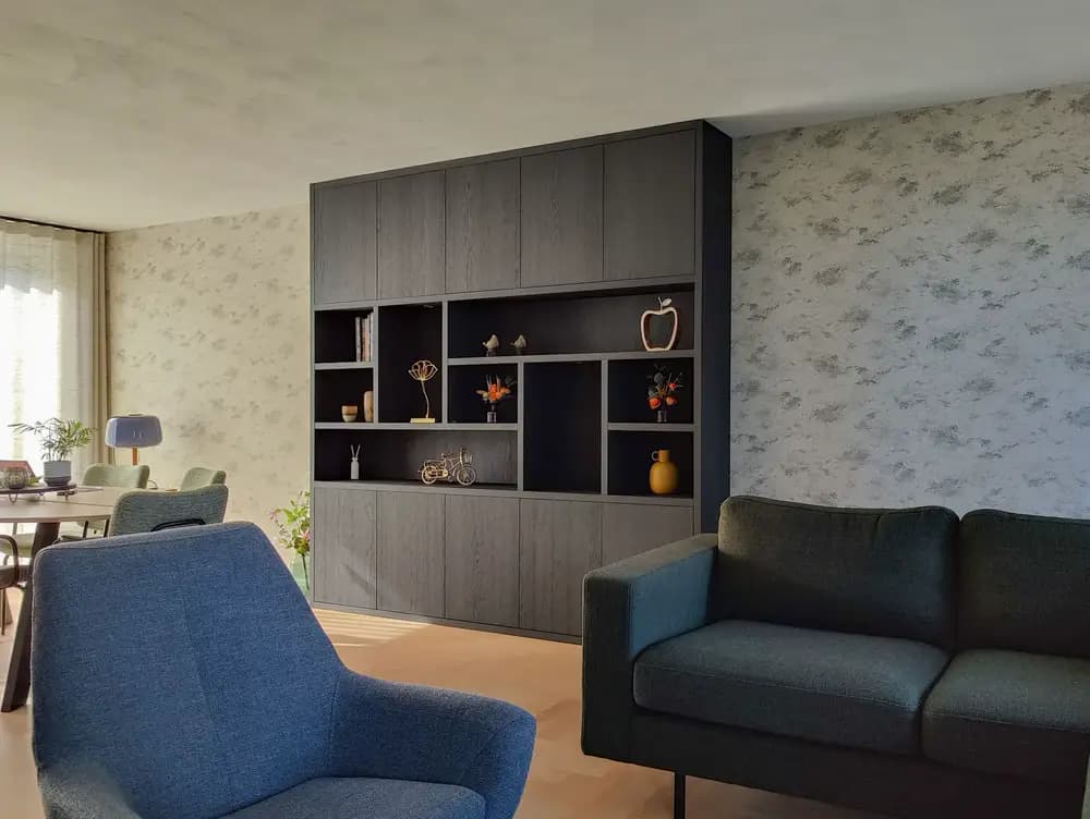 Op maat gemaakte donkere houtlook kastenwand in een gezellige woonkamer in Harderwijk.