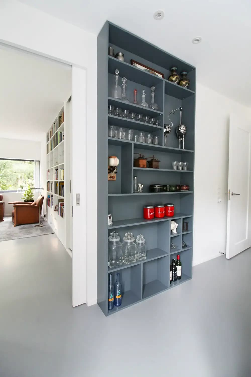 Grijze vakkenkast met open vakken woonkamer