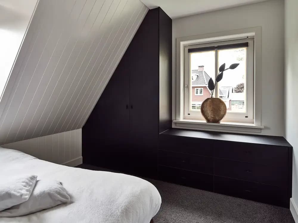 Schuine kledingkast onder het raam