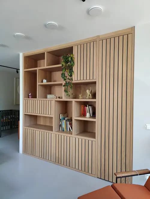 Woonkamerkast op maat met vakken en lattenbekleding in Hilversum, uitgevoerd in geolied eiken fineer.