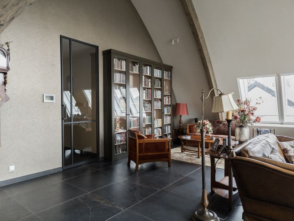 Zijaanzicht van een op maat gemaakte boekenkast met glazen deuren en houtdecor interieur in een traditionele woonkamer in Barneveld.
