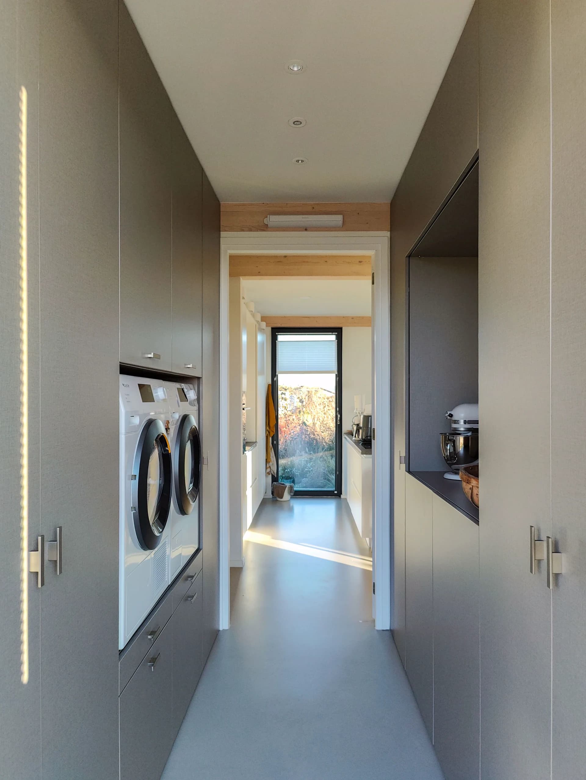 Moderne wasmachinekast met ingebouwde wasmachine en droger, geplaatst in een bijkeuken in Almere.