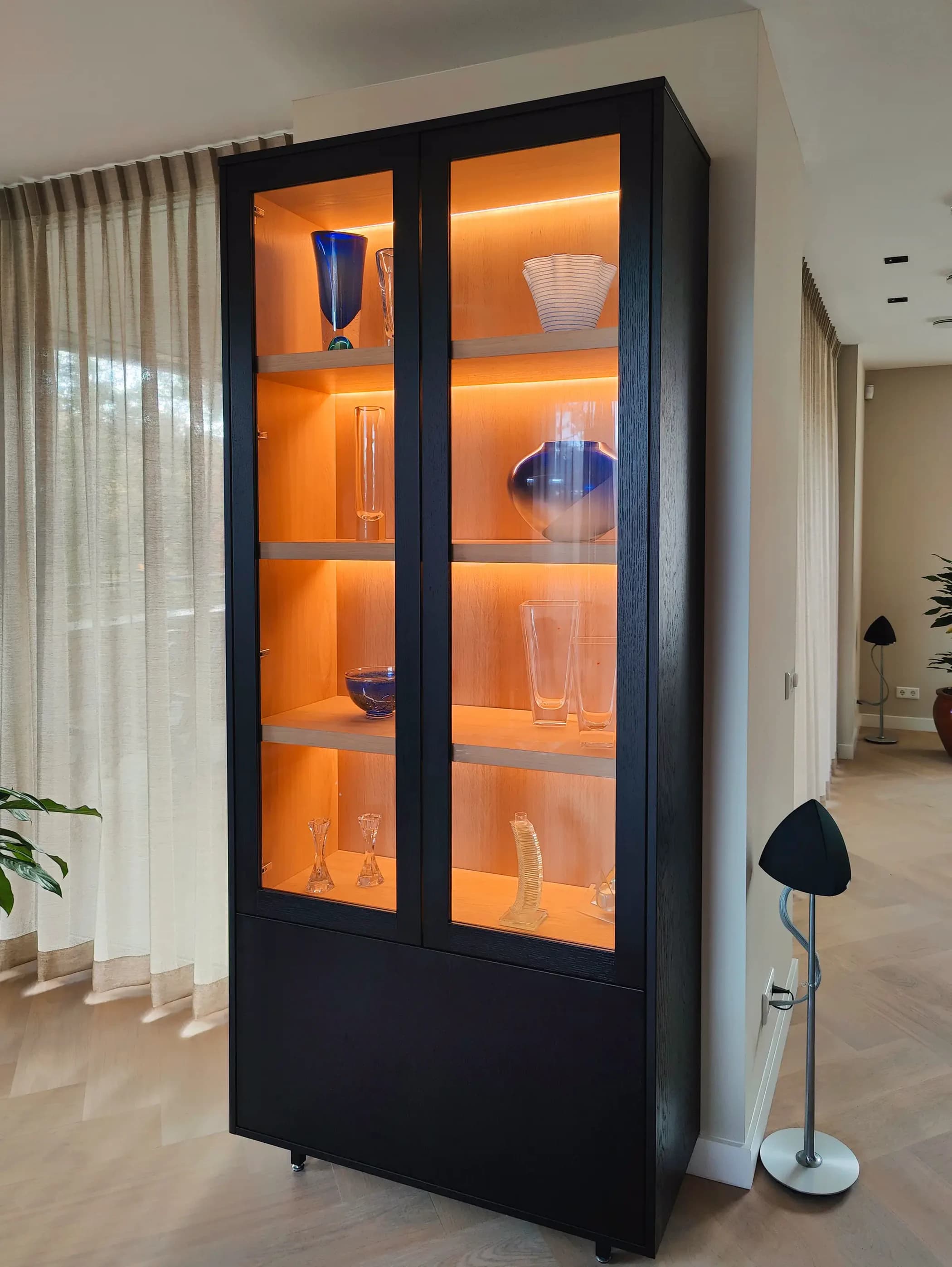 Zwarte buffetkast met glazen deuren en ingebouwde ledverlichting