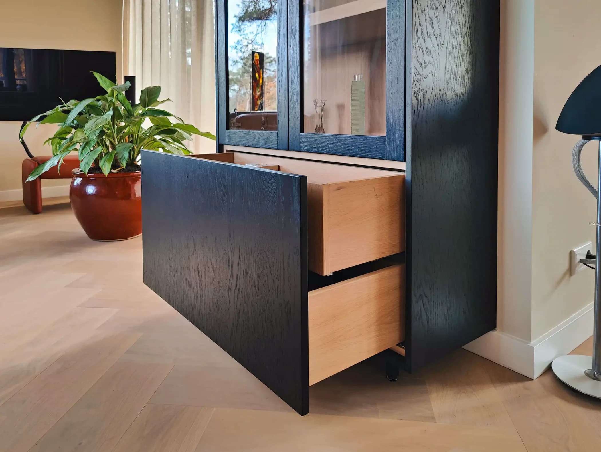 Dubbele lades in zwarte buffetkast met licht houten interieur