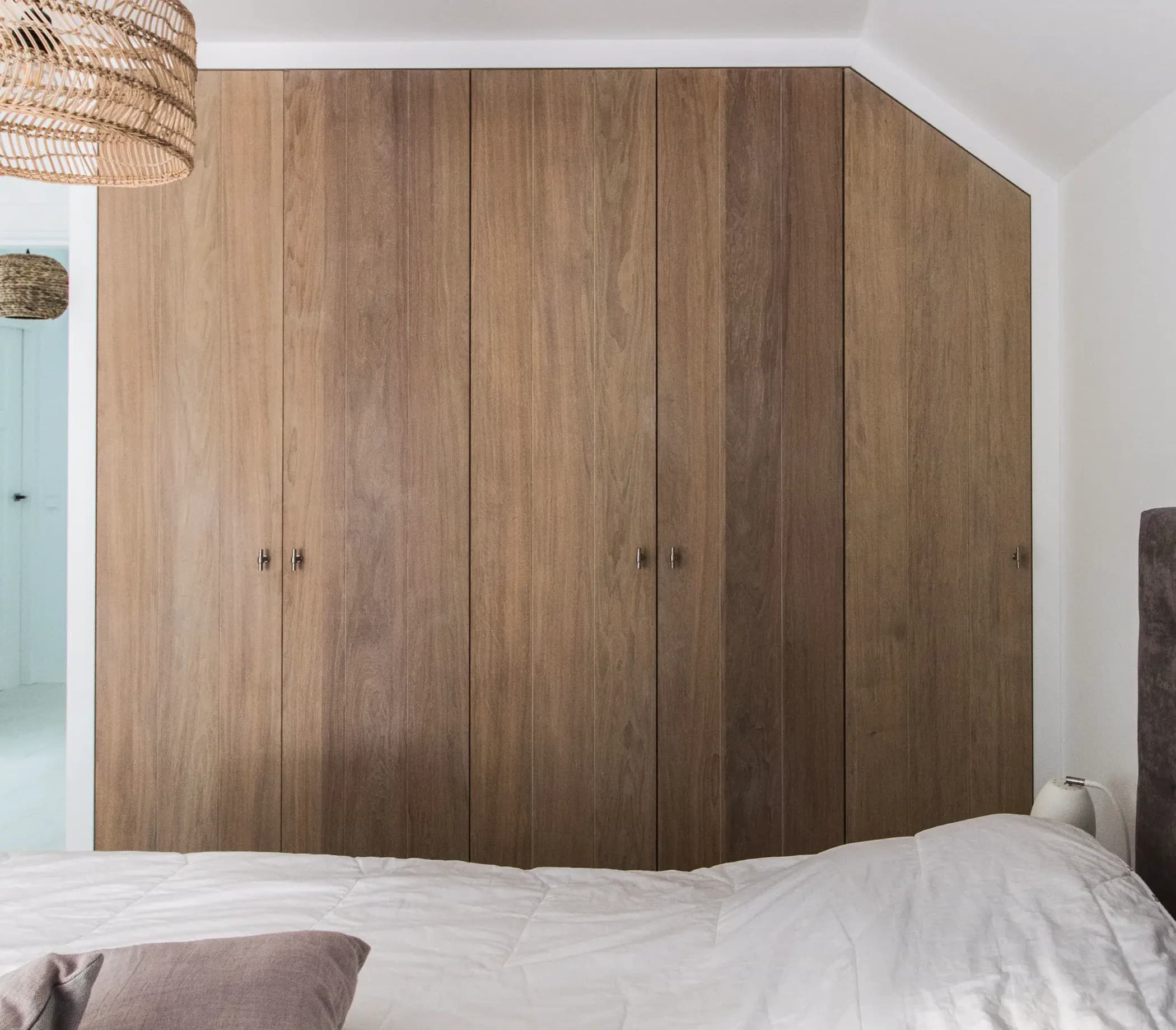 Ingebouwde kledingkast met schuine hoek afgewerkt in rustiek eiken fineer in Veenendaal.